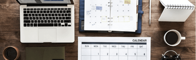 IMage of laptop and planner with notebooks