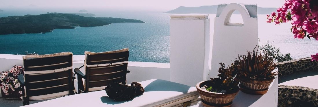 Terraza de un hotel con paredes blancas y vistas a la playa